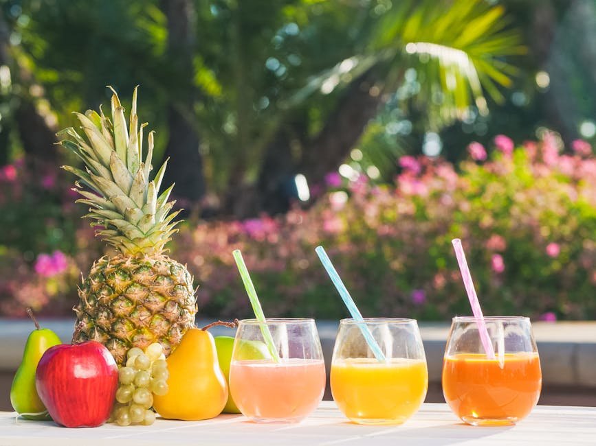 A vibrant display of assorted fruit juices and fresh fruits with a lush garden backdrop.